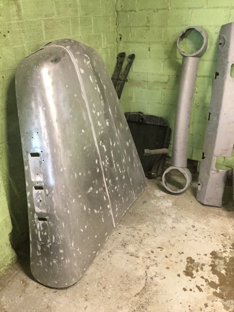 truck hood in corner of garage next to other truck parts