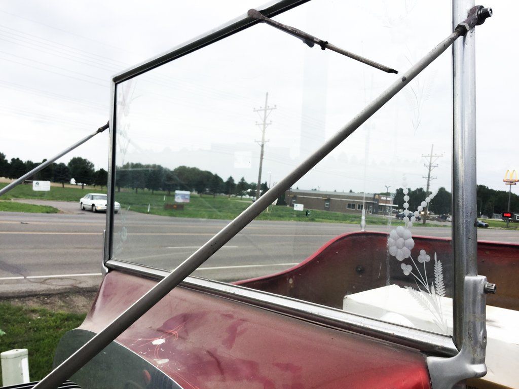 close up of car windshield with flower and wheat design on lower right corner