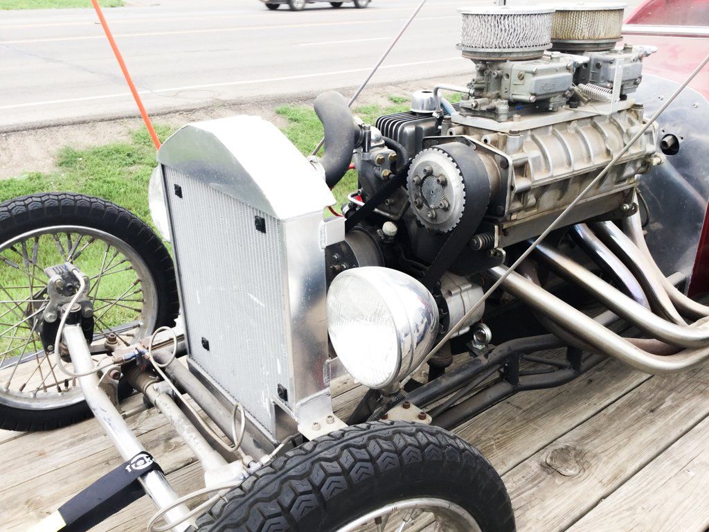 close up of front headlights and engine with hood removed