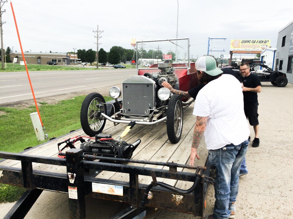 front view of car with dakota kustomz staff looking at car engine