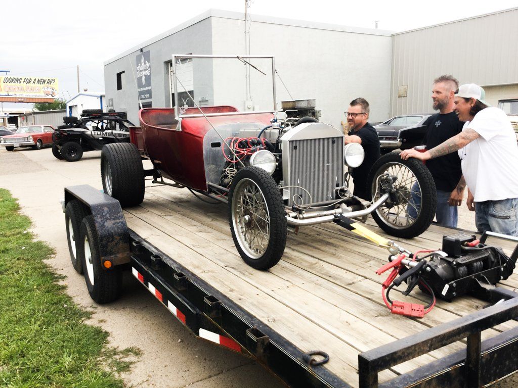 dakota kustomz team admiring ford t-bucket on flatbed truck