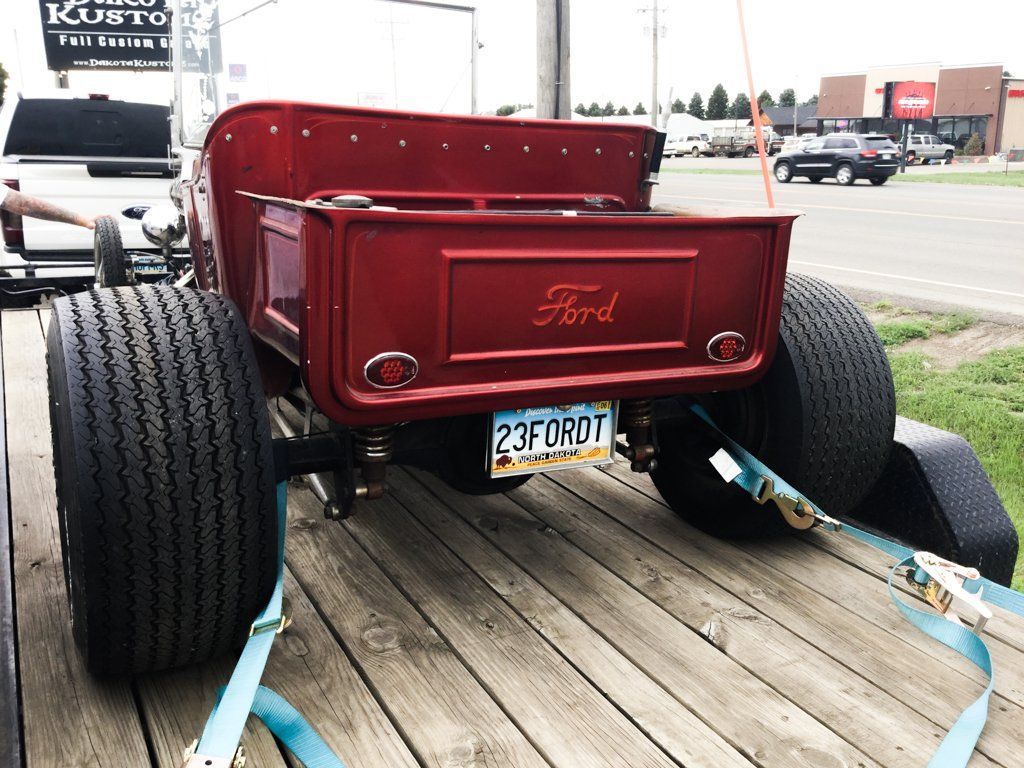 rear view of car strapped onto flat bed trailer
