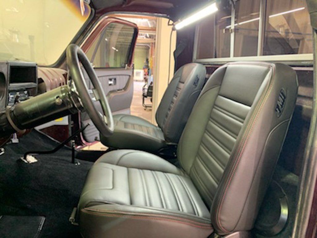 interior view of front seats with passenger door open and steering wheel