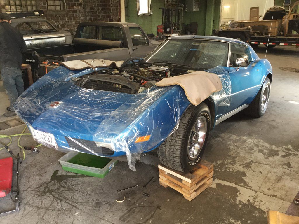 car with no engine suspended by crates