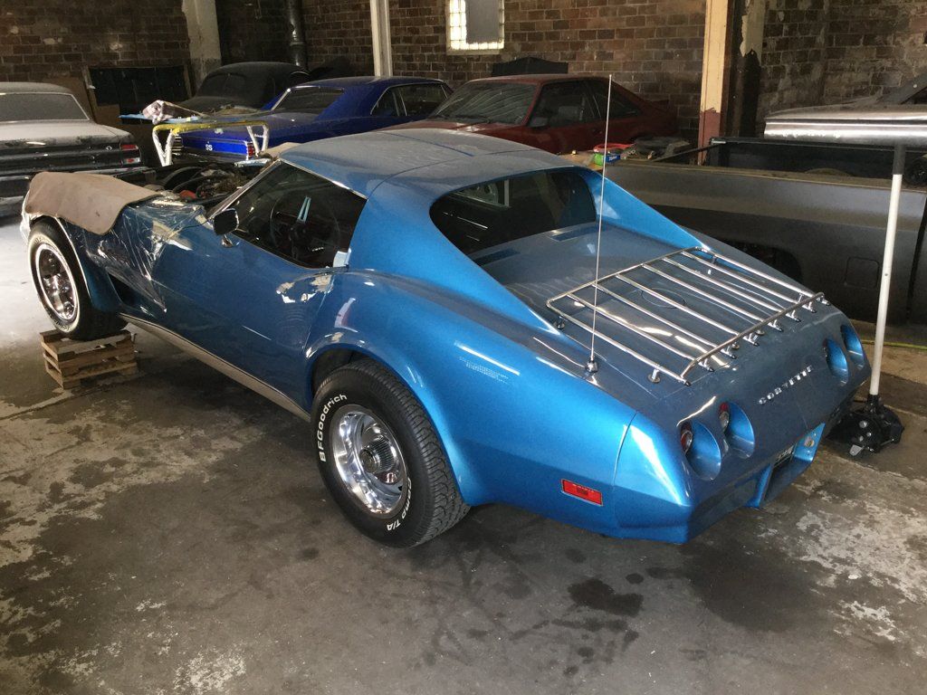rear view of muscle car with plastic on hood in garage
