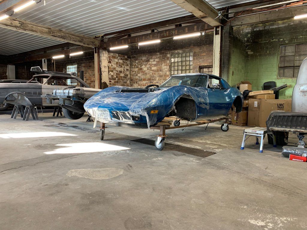 full front side view of car body suspended in service bay