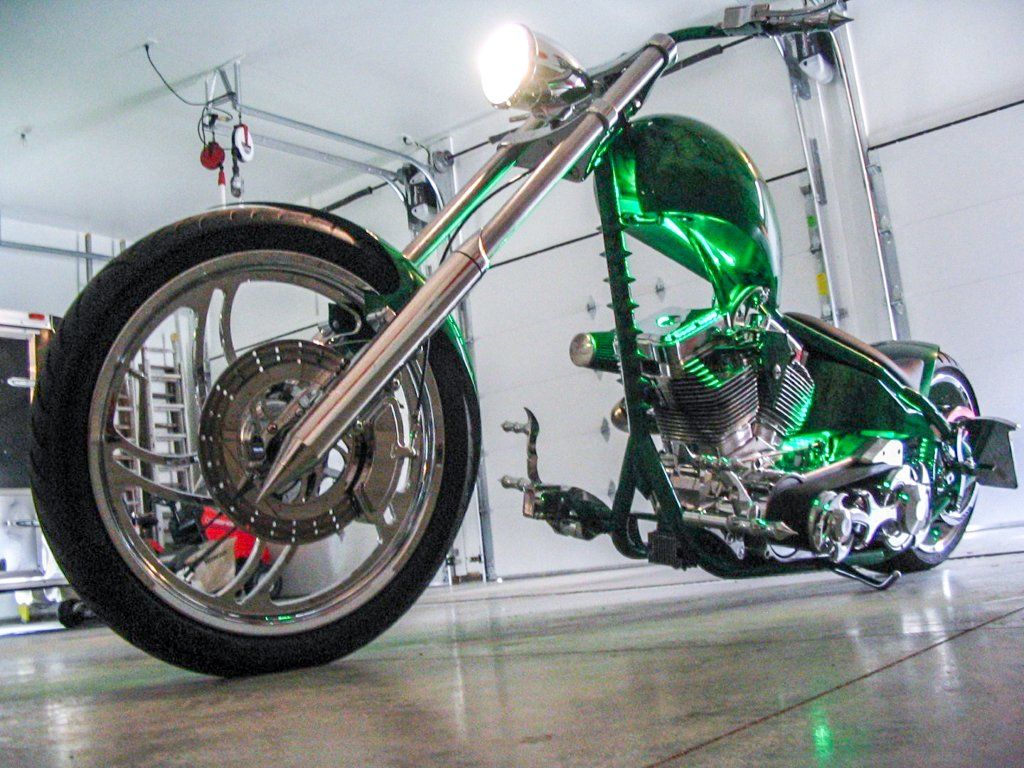 green and chrome customized chopper inside garage