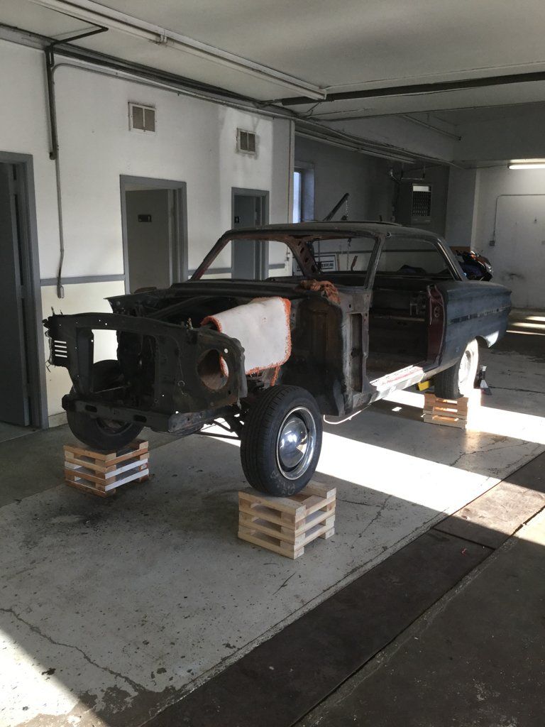 front view of car frame with no engine on crates