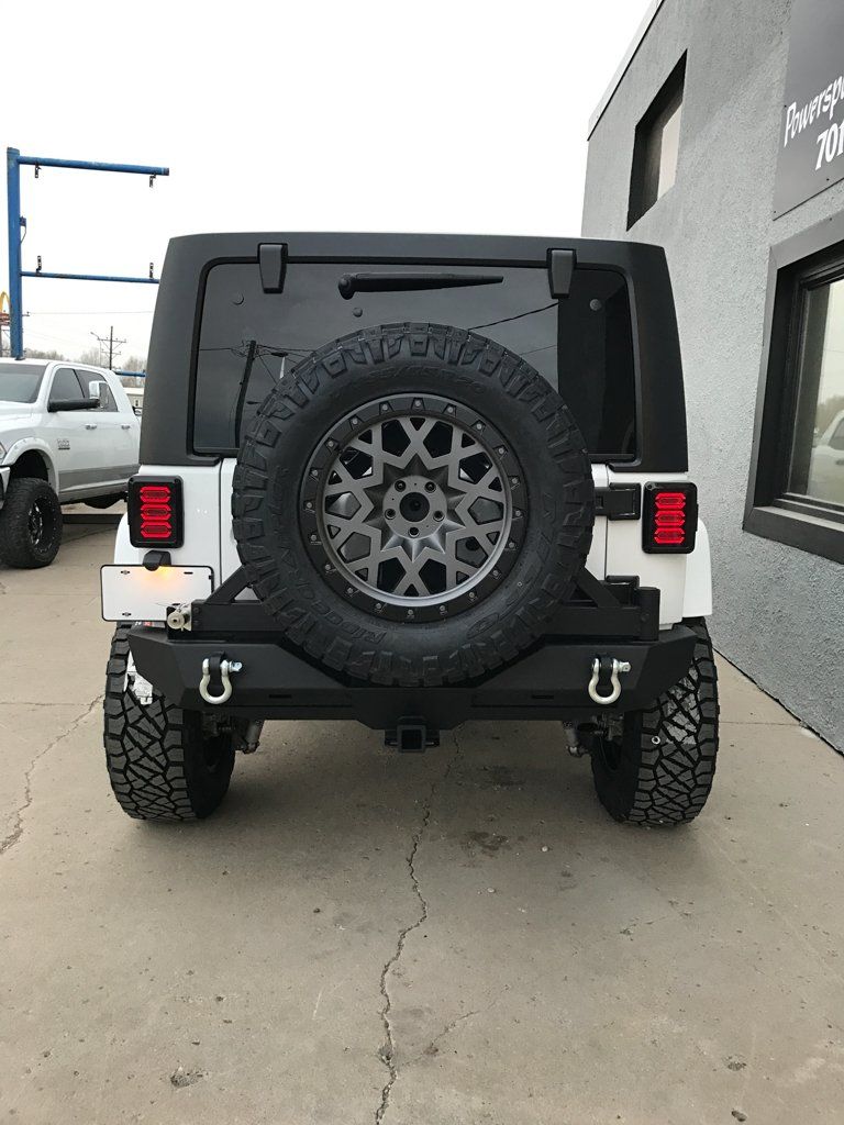 rear view of white customized jeep with customized tire