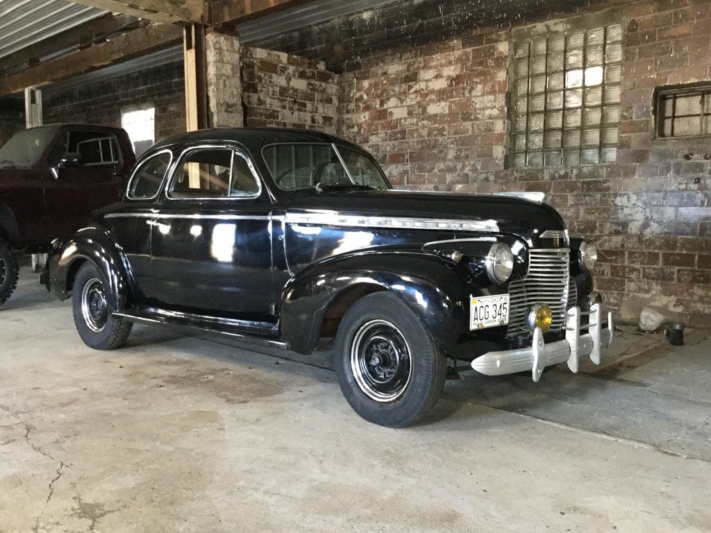 front view of customized black hot rod in garage