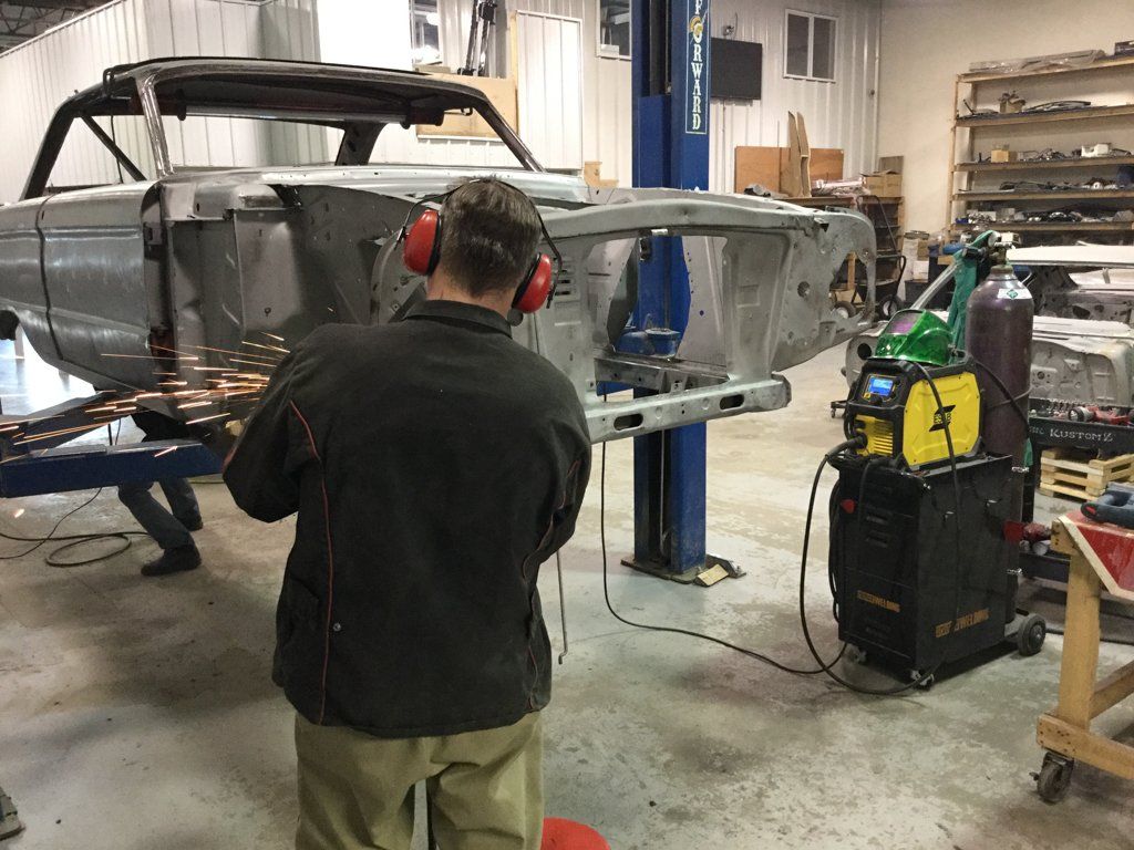 worker wearing hearing protection detailing car body