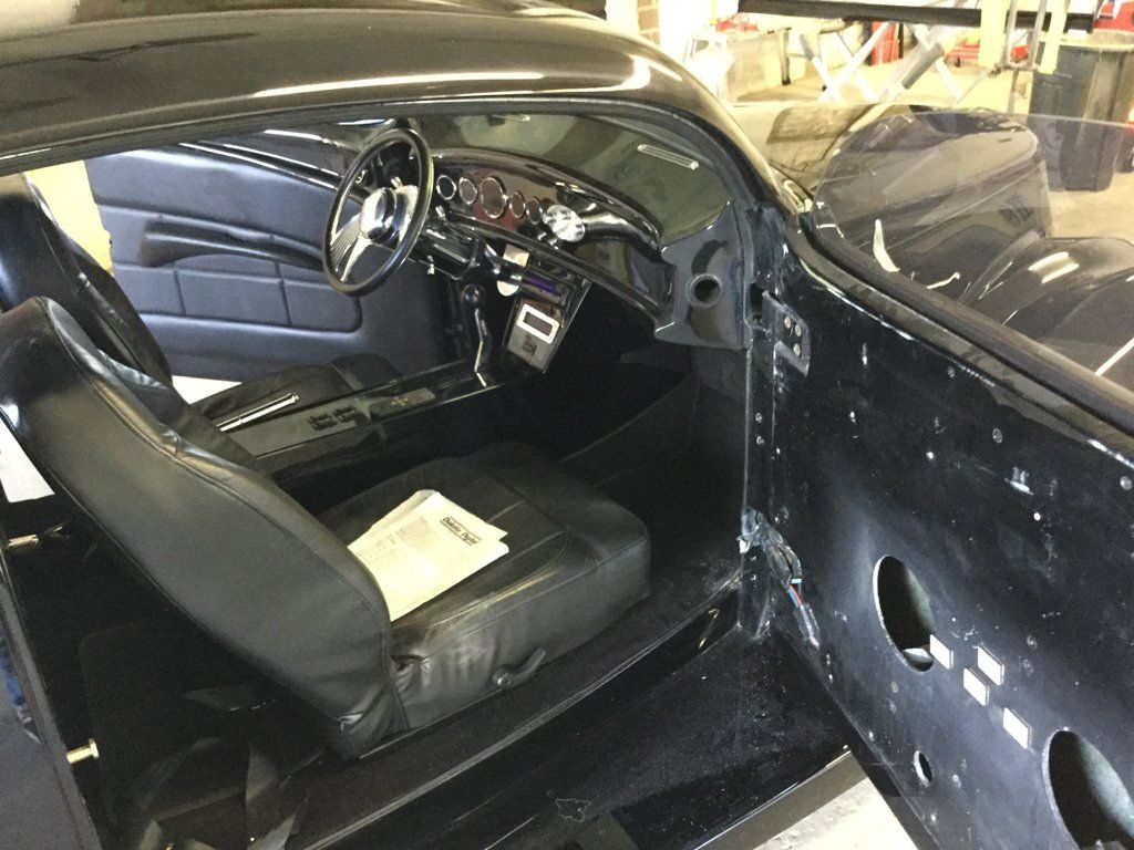 interior shot of custom black 1937 ford tudor hot rod with door opened before renovation