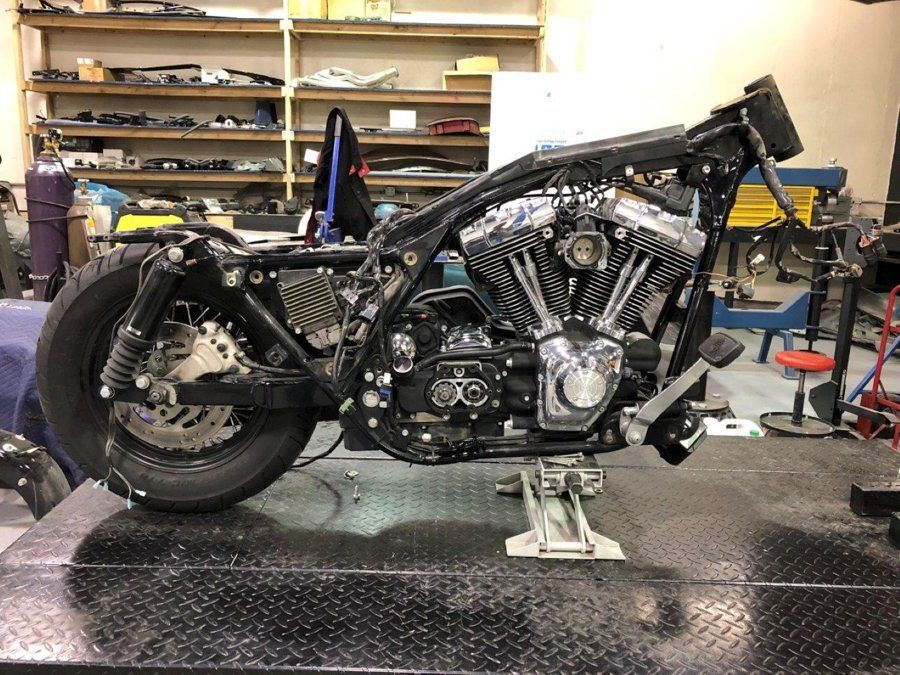 side view of black chopper with handle bars removed and no front wheel