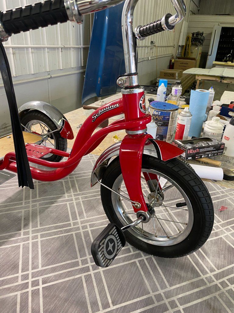 side view of custom red tricycle on workbench