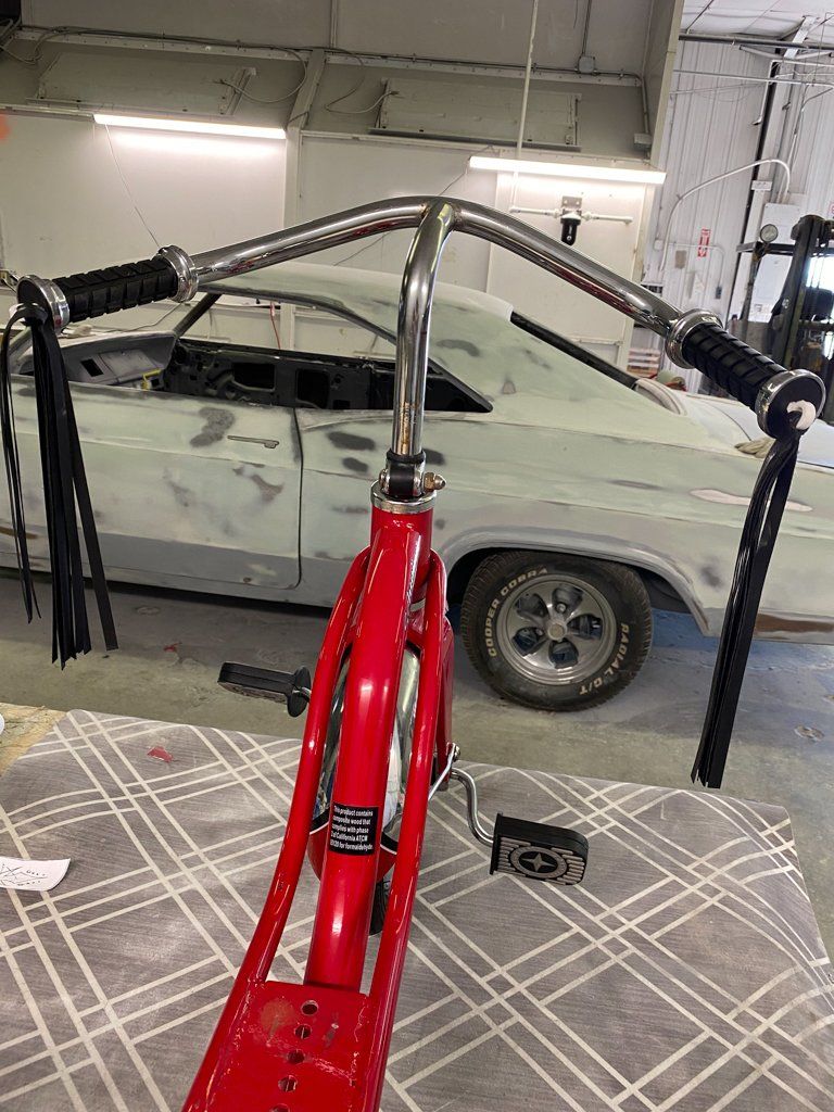 rider point of view of custom red tricycle on workbench