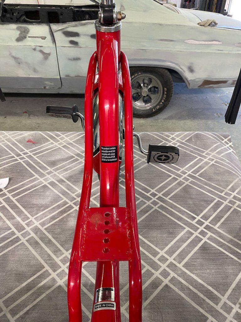 rider point of view of custom red tricycle on workbench with seat removed