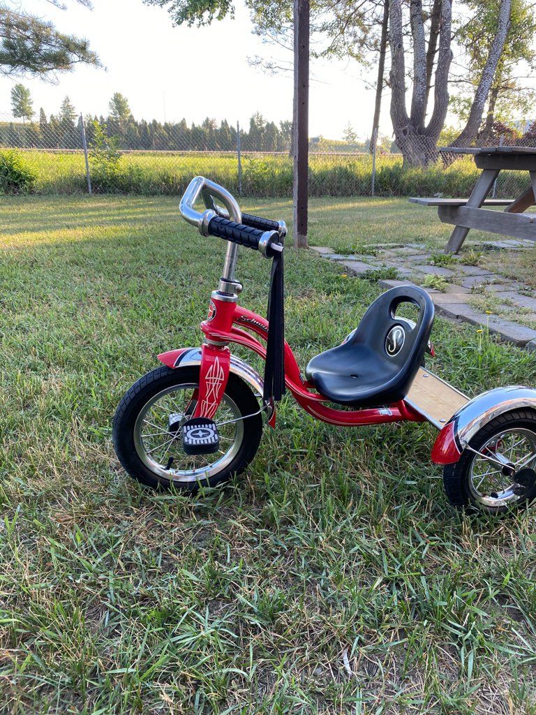 side view of custom red tricycle on grass