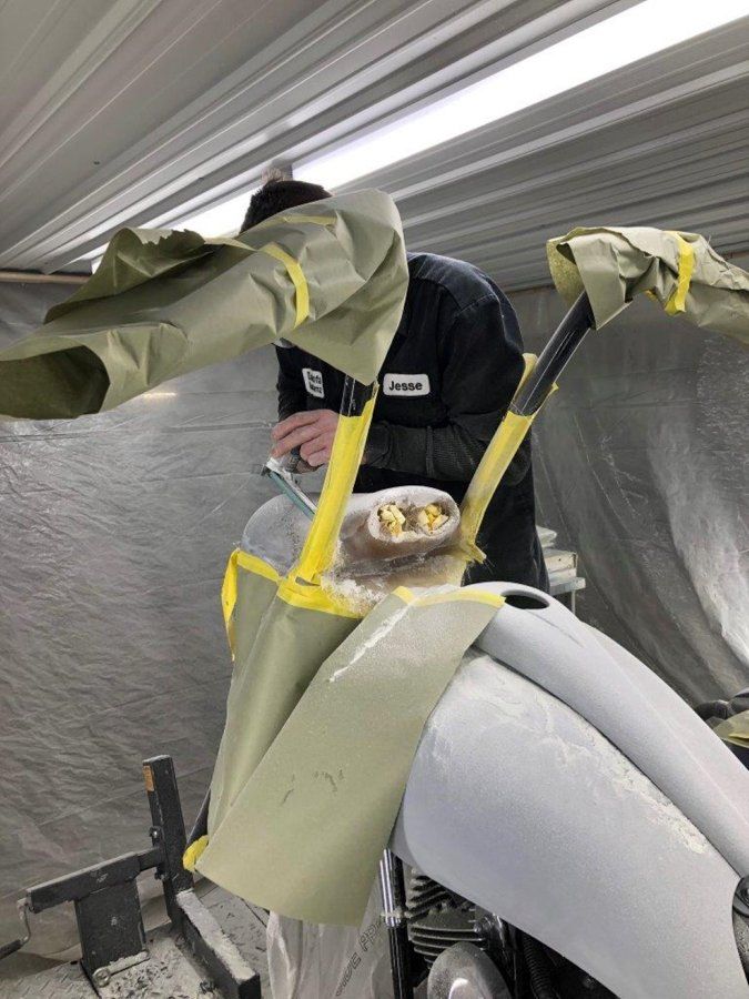 black chopper covered in paper and tape for painting