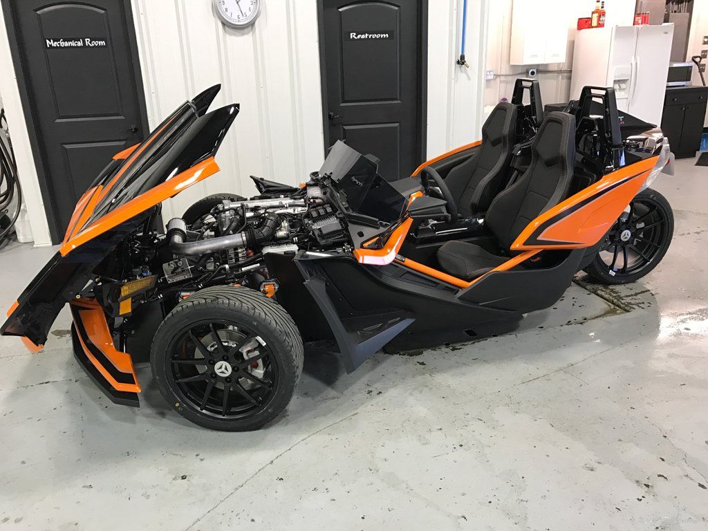 custom orange and black polaris slingshot side view with hood up