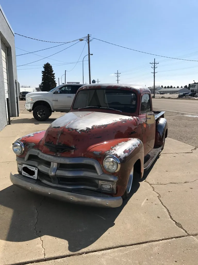 alternate front view of red customized pickup outside