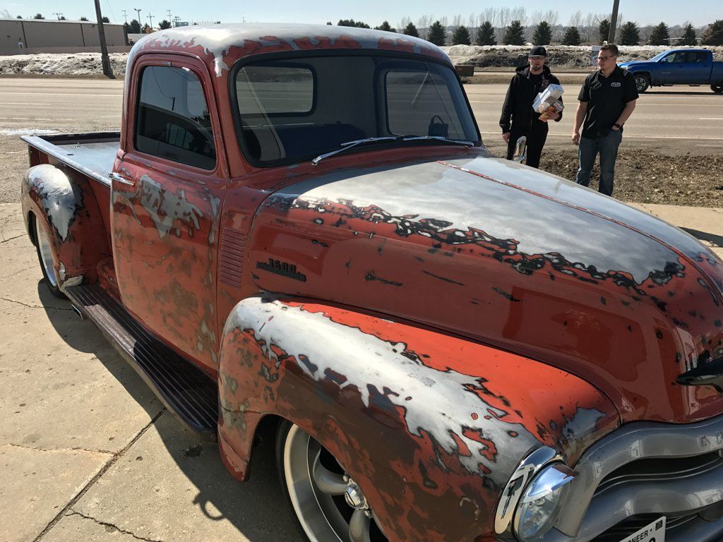 front view of red customized pickup outside