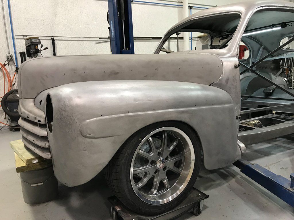 close up of front fender of ford sedan stripped of paint