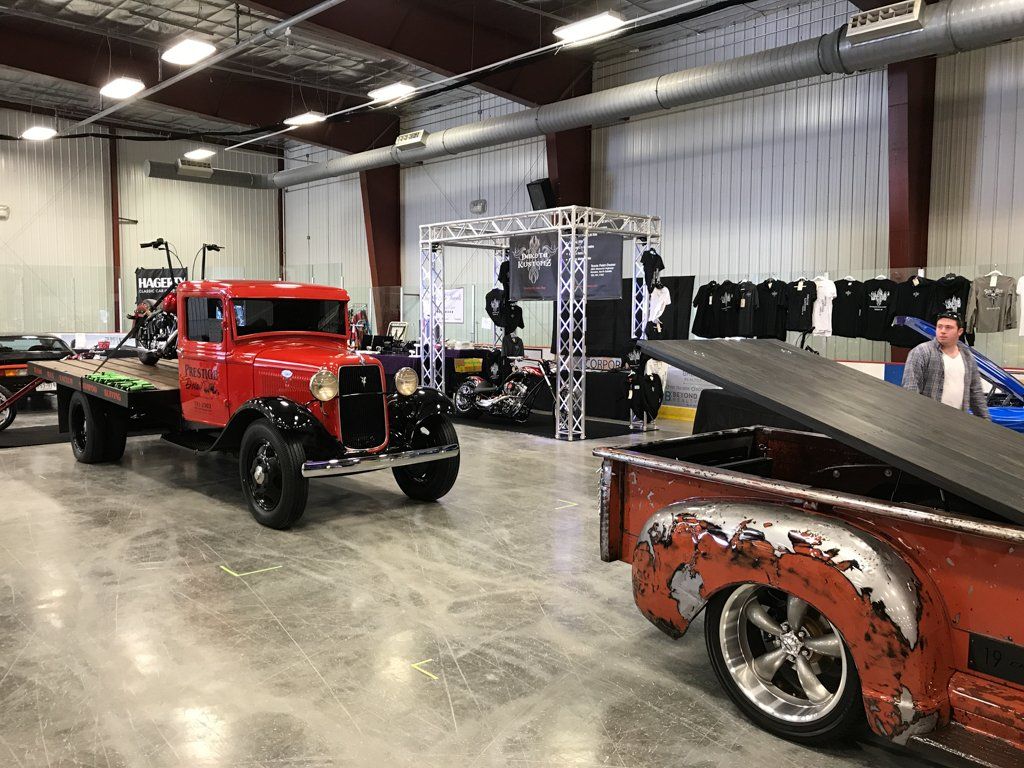 rear of mitch truck and old school bucket truck flatbed in showroom
