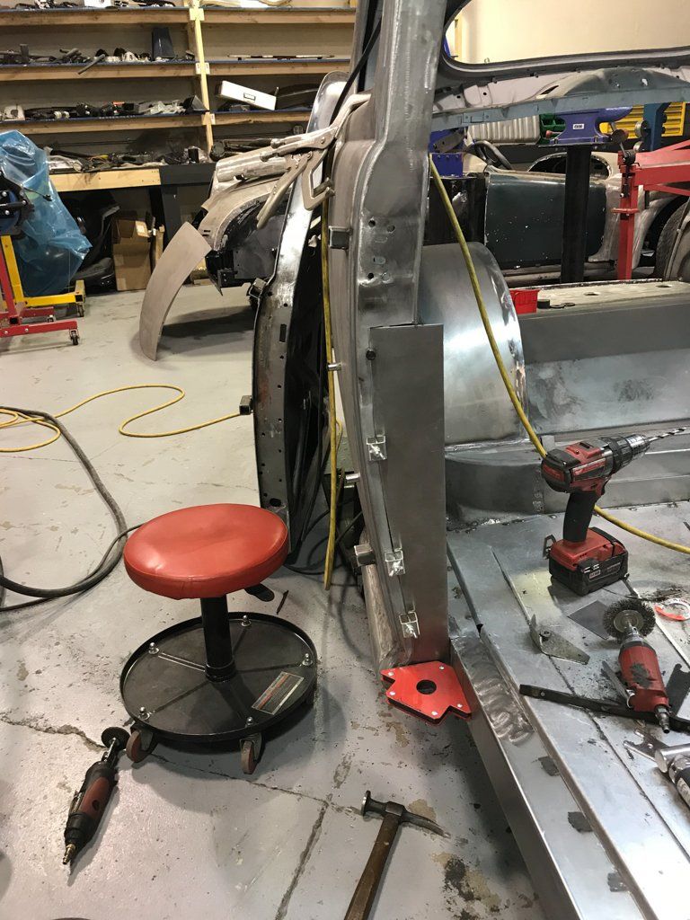 working stool next to stripped car