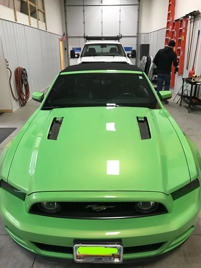 front view of solid lime green mustang in garage