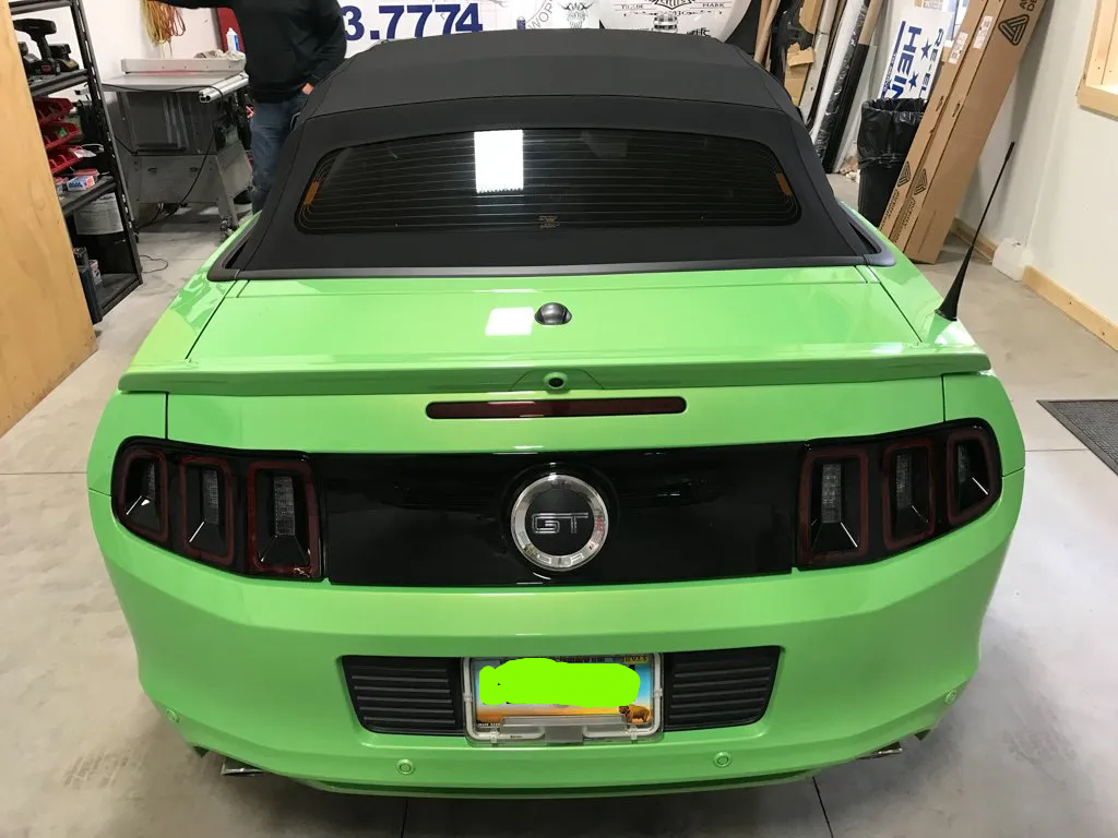 rear view of solid lime green mustang in garage with license plate