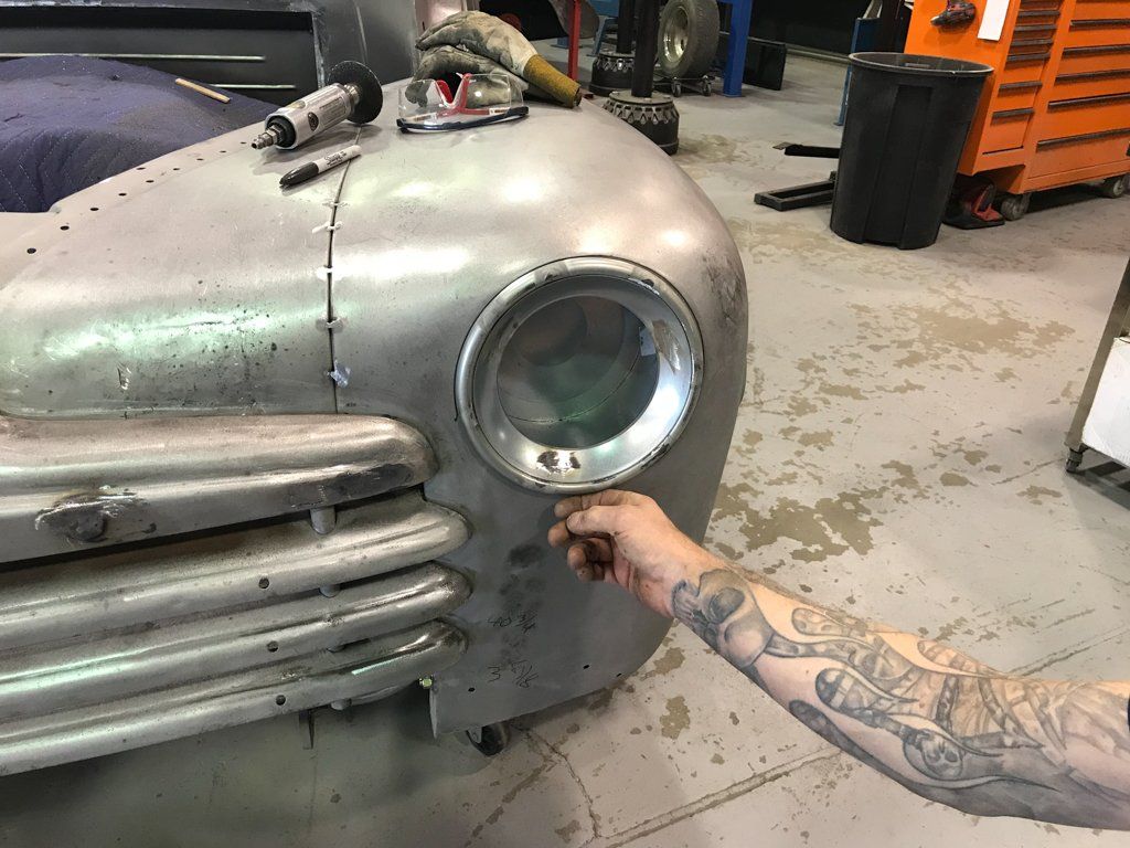 front headlight socket with mechanic's hand under headlight
