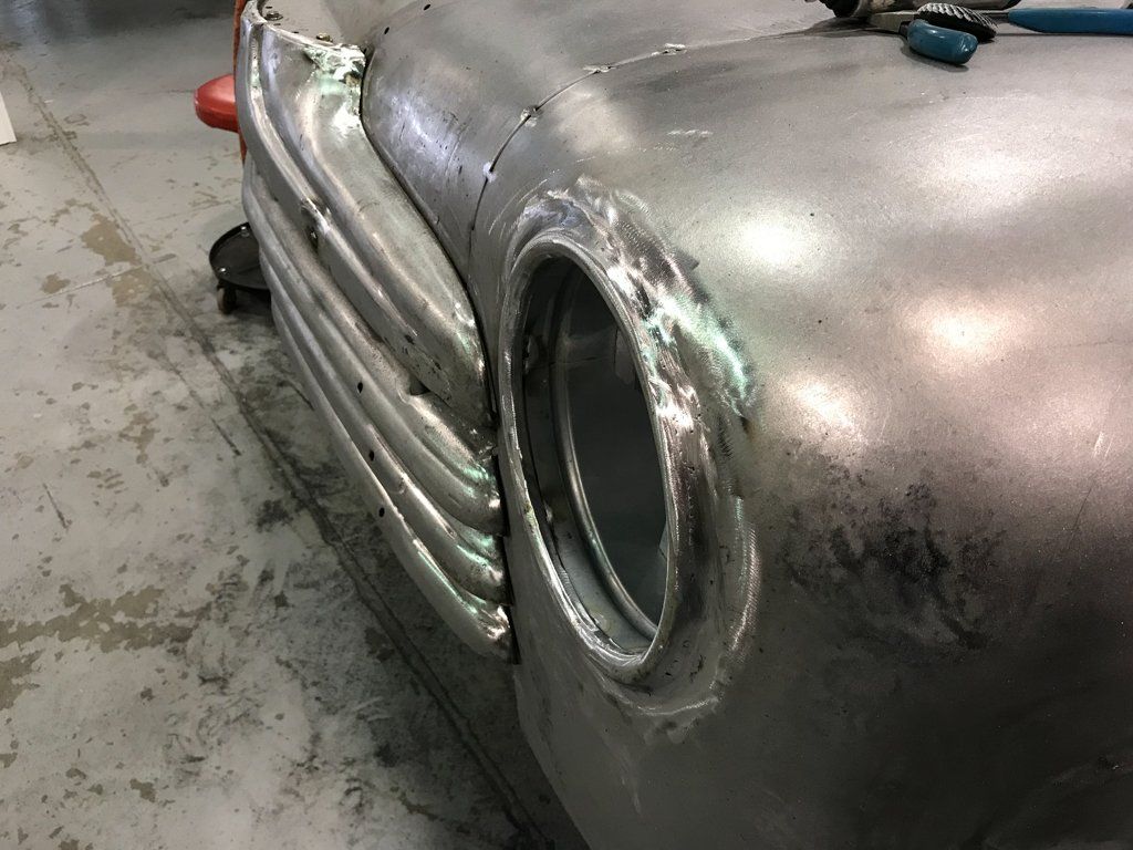 close up of front grill and removed headlight of car