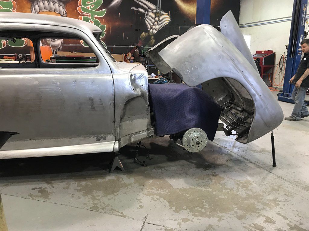 side view of car with wheels removed and hood open