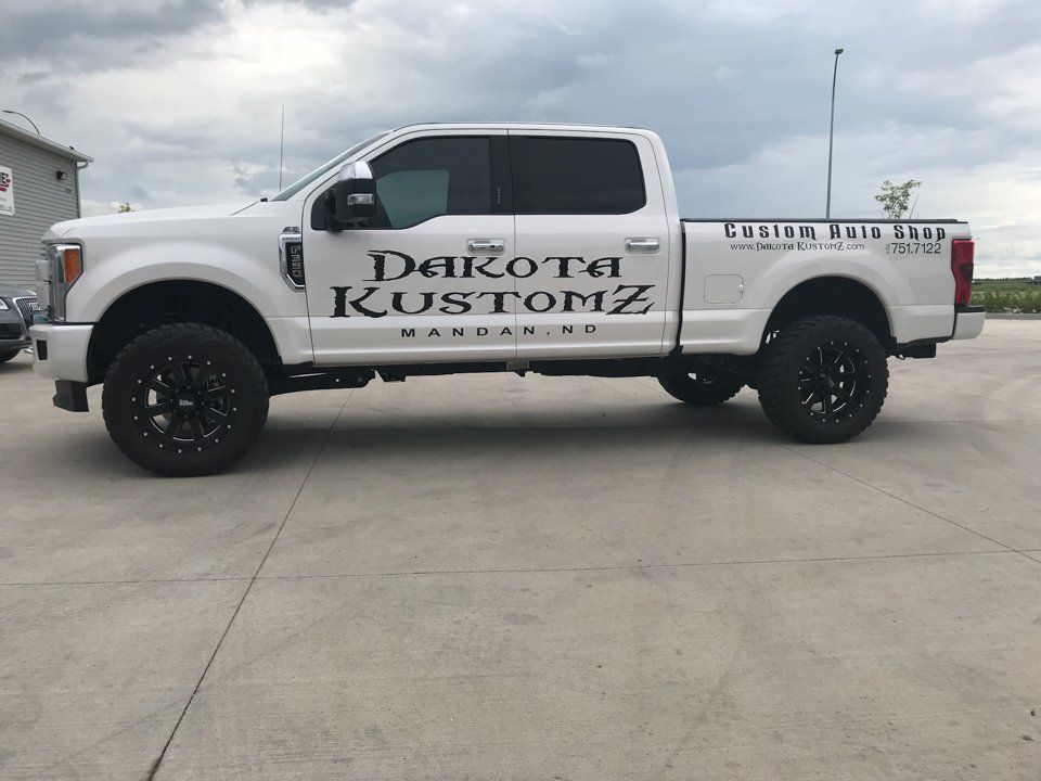 side view of custom white 2017 Ford F350 Diesel Dakota Kustomz Truck with Dakota Kustomz logo