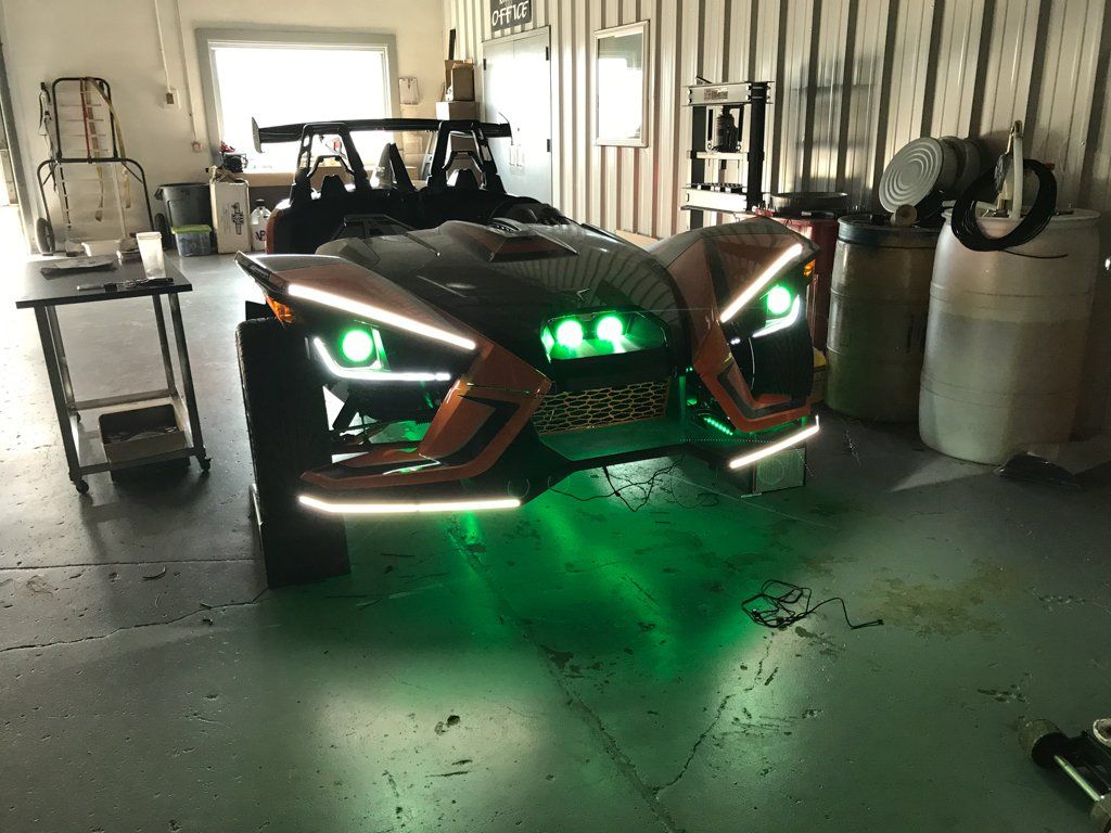 custom orange and black polaris slingshot front with green LED lights