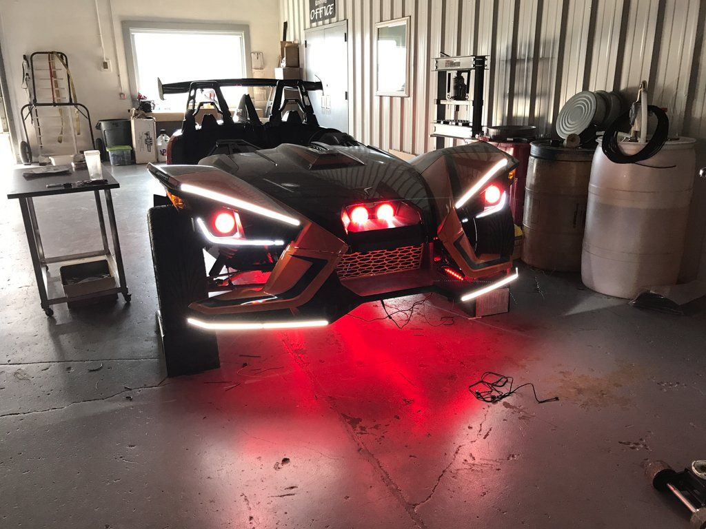 custom orange and black polaris slingshot front with red LED lights