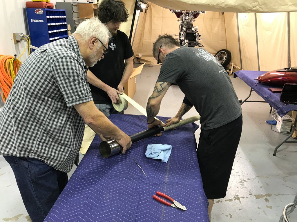 mechanics working on piping on work table