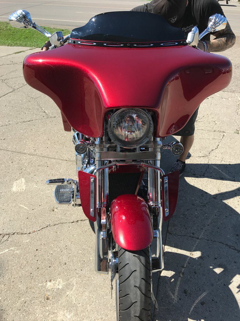 front view of rear view of customized red and chrome motorcycle in garage with dakota kustomz graffiti art