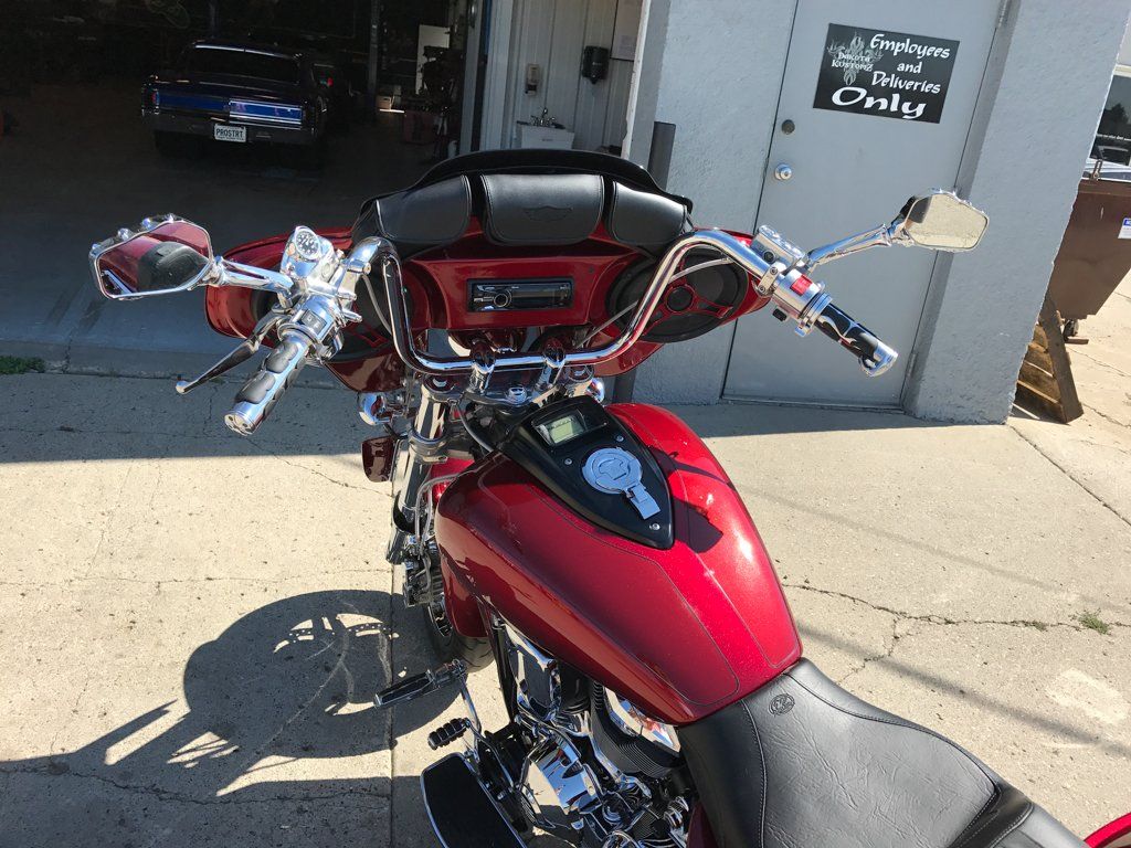 close up of driver console of rear view of customized red and chrome motorcycle in garage with dakota kustomz graffiti art
