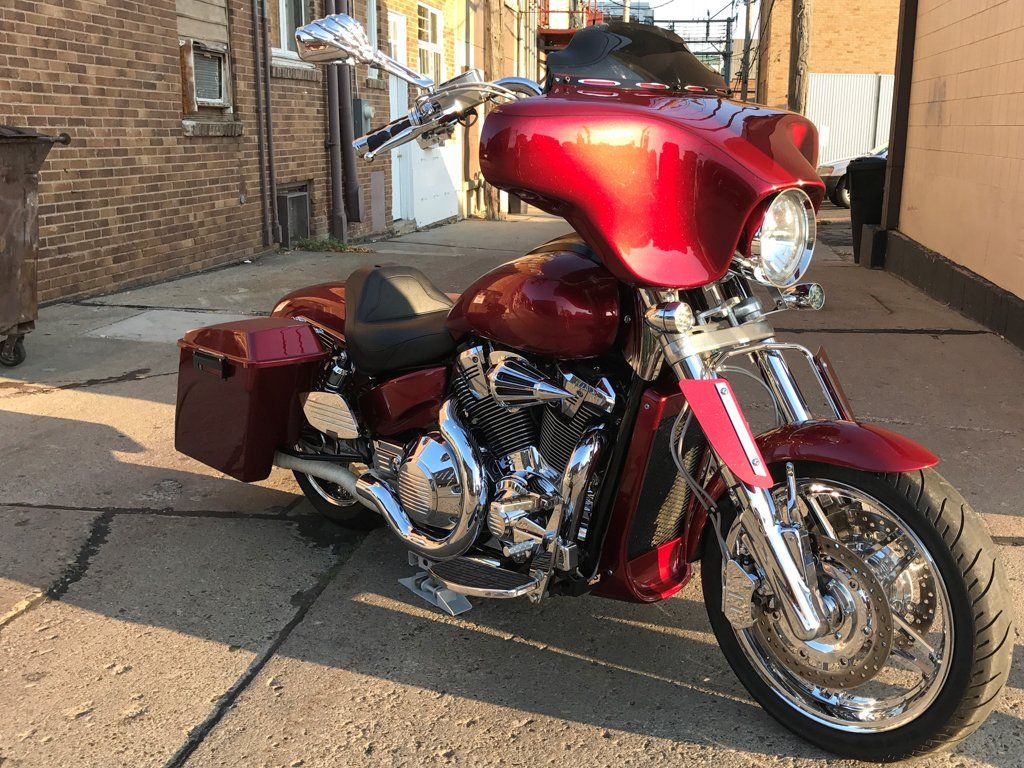 red and chrome customized motorcycle in alley