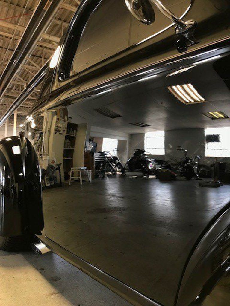 view of dark empty space in workshop with vehicles in the background