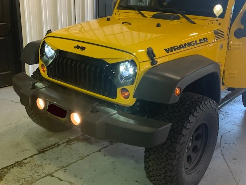 yellow jeep with lights on in garage