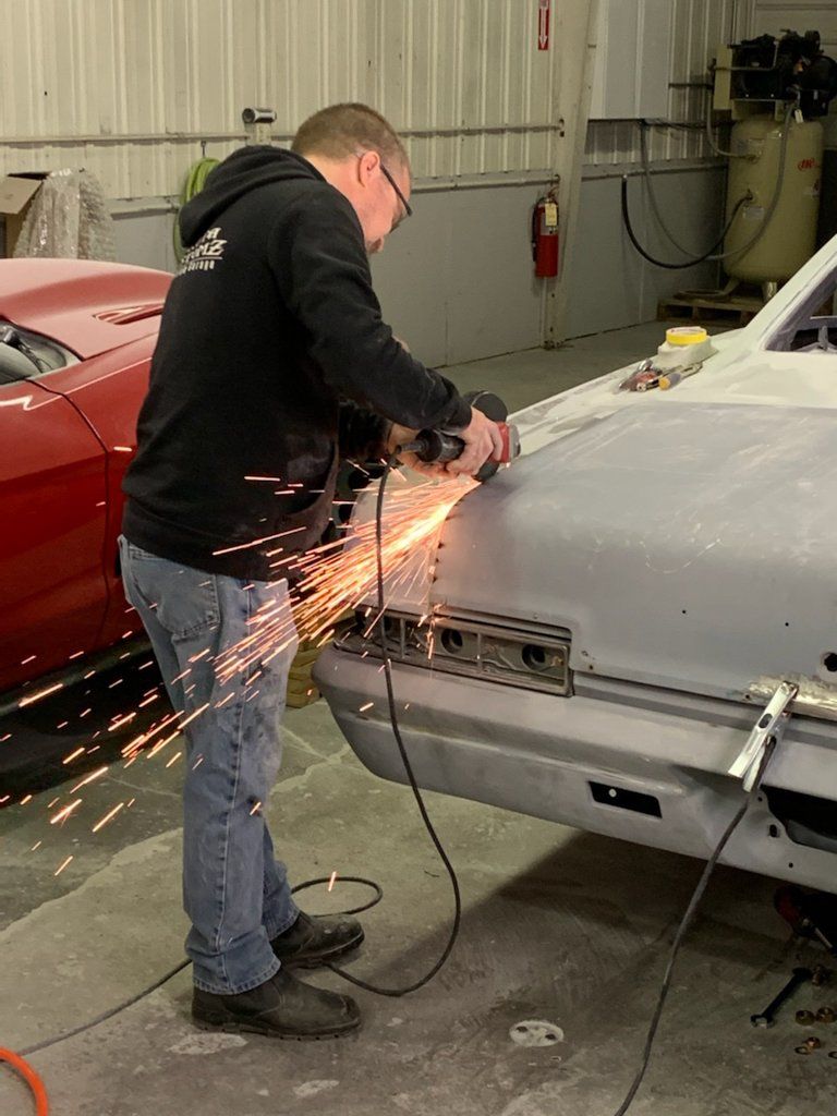 mechanic creating sparks with tool on car