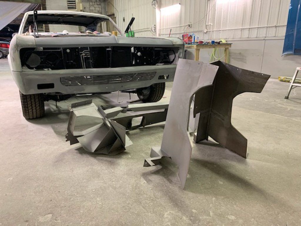 car parts on ground in front of car