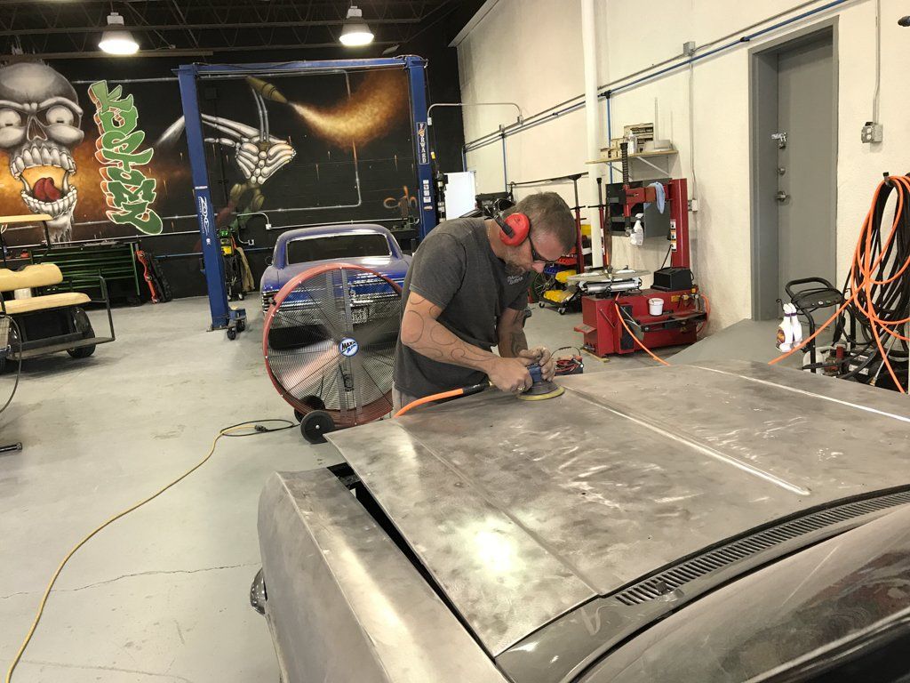 mechanic wearing hearing protection while buffering car hood