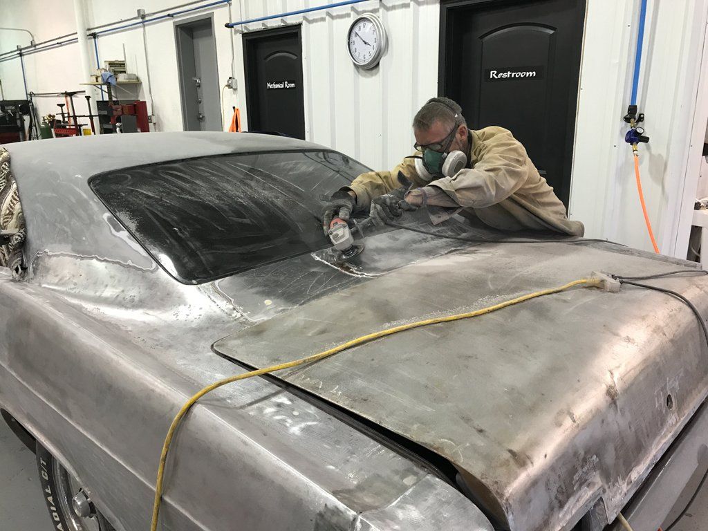 detail worker detailing under windshield of car