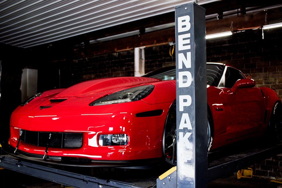 custom red 2006 corvette car on service bay