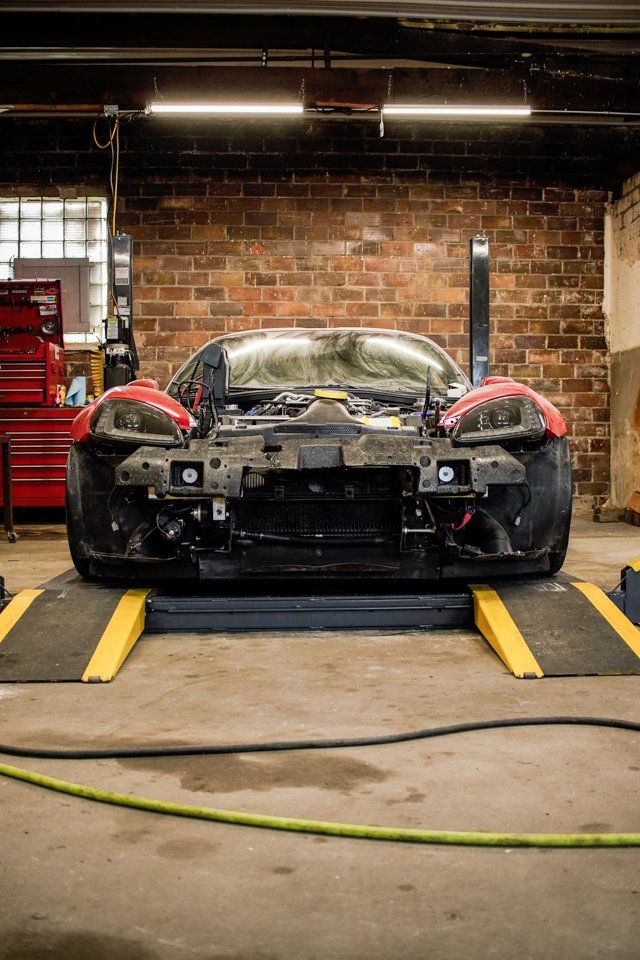 front view of corvette on service bay with fender and hood removed