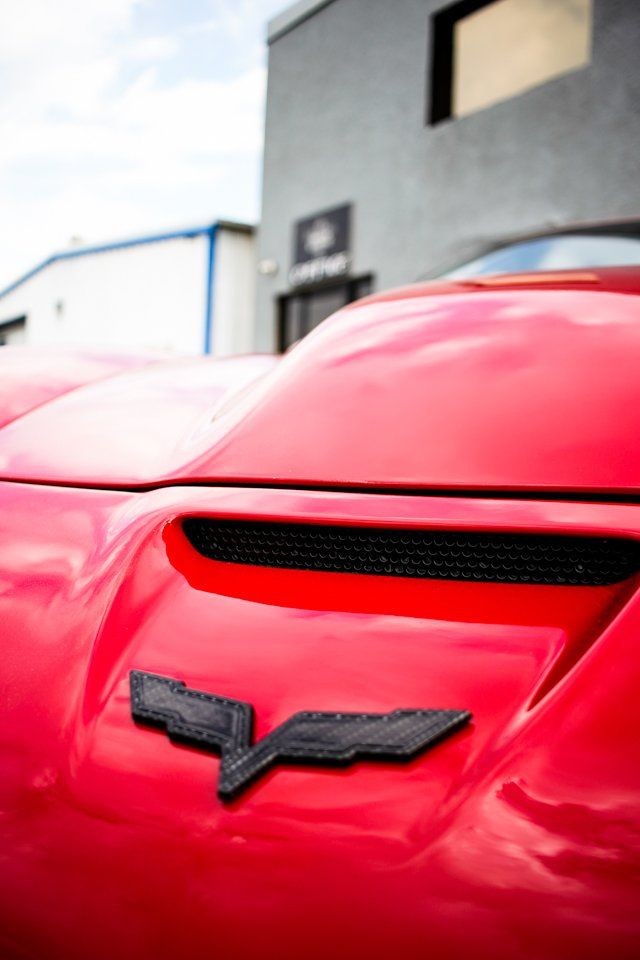 close up of corvette logo on red car