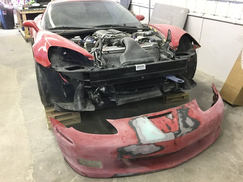 red corvette with hood and front fender removed